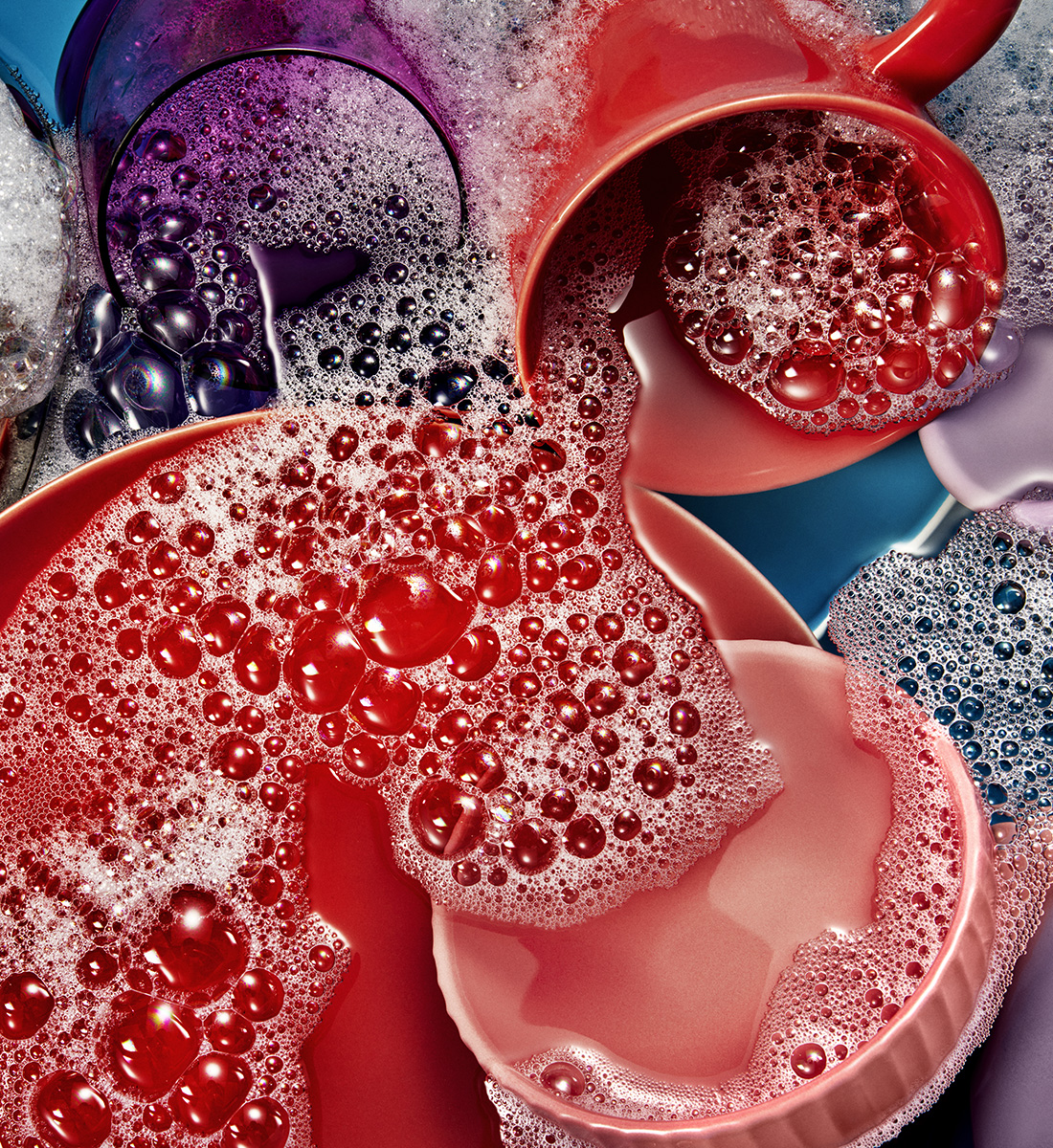 Colorful dishes in sudsy water.